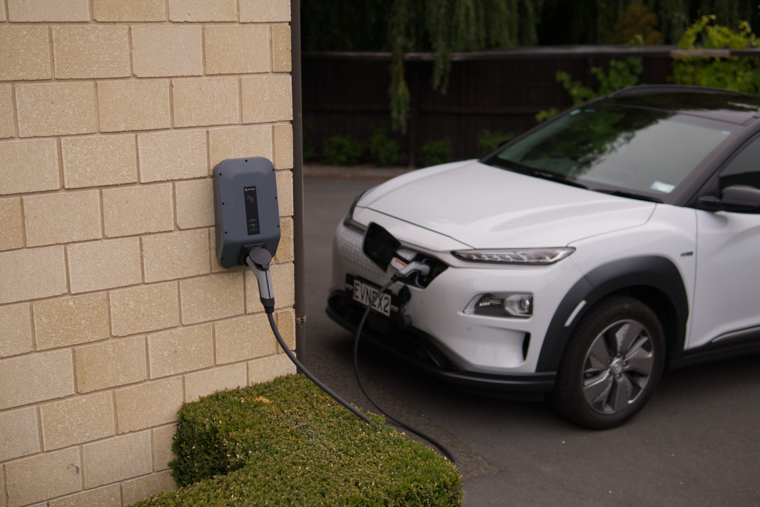 Black charger plugged in on white car