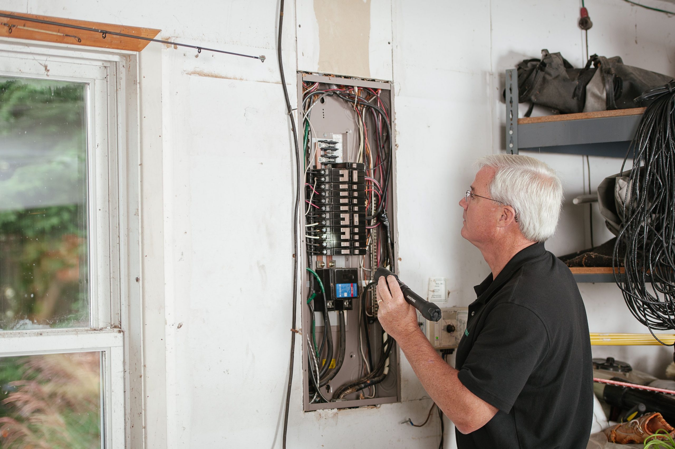 Do I Need to Upgrade My Consumer Unit for an EV Charger? 1 Electrician inspecting a consumer unit before EV charger circuit installation